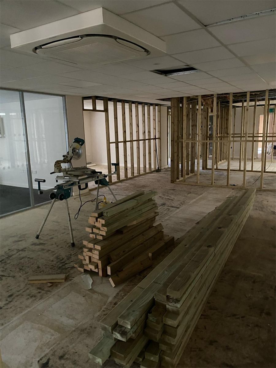Interior fit-out during construction — timber stud walls and a mitre saw